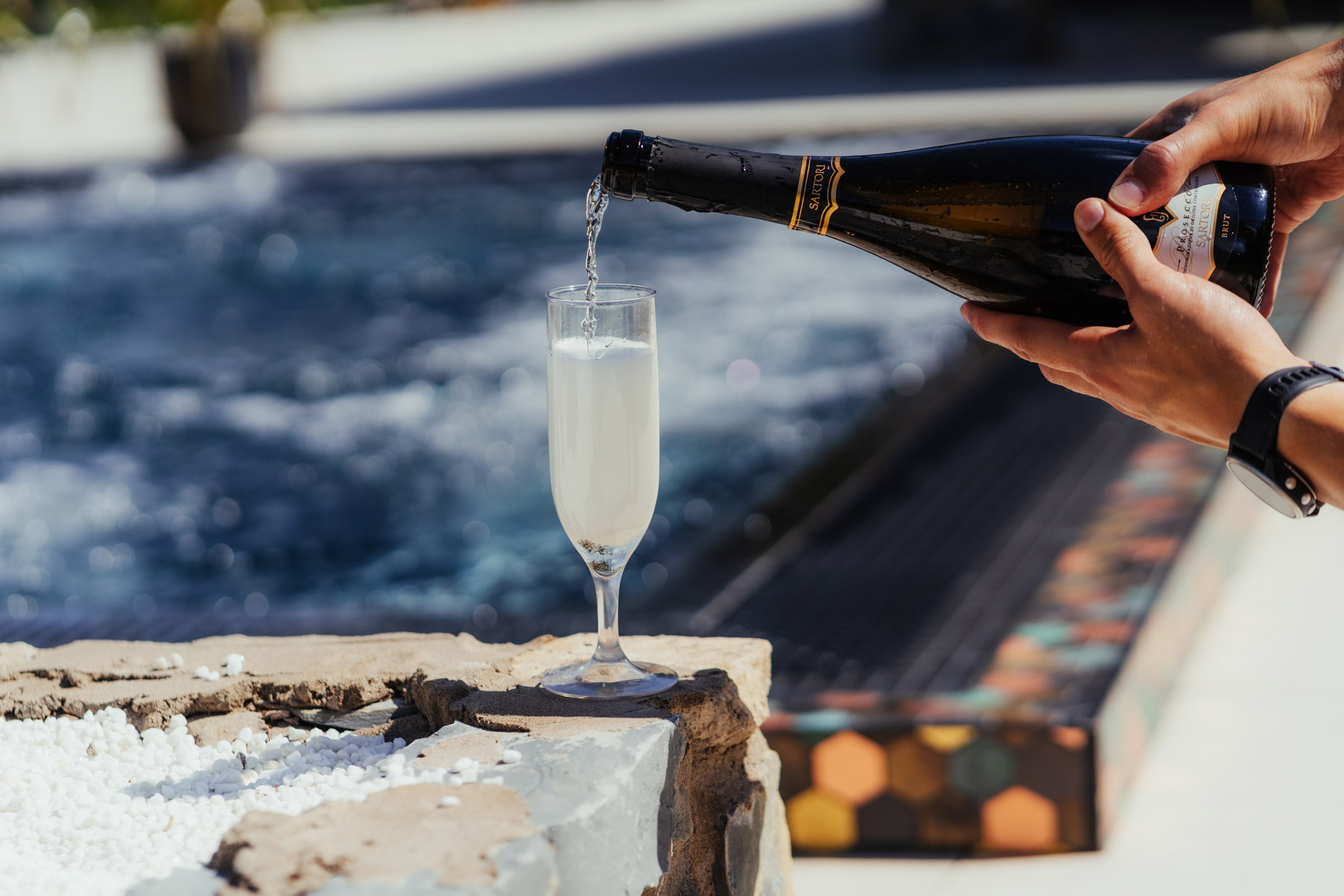 Forest View champagne being poured near pool